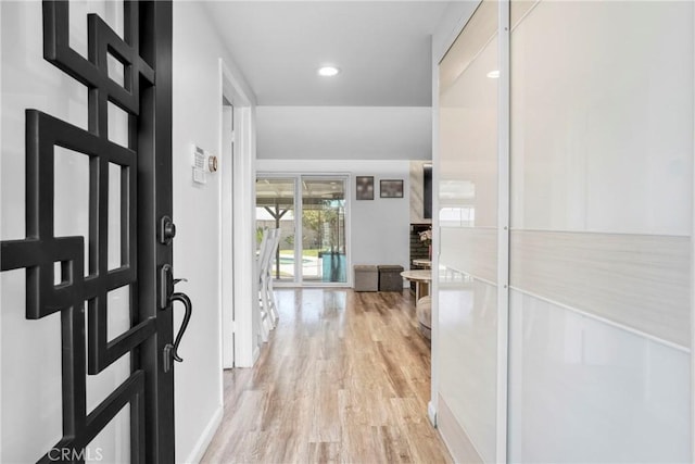 foyer entrance with recessed lighting, light wood-type flooring, and baseboards