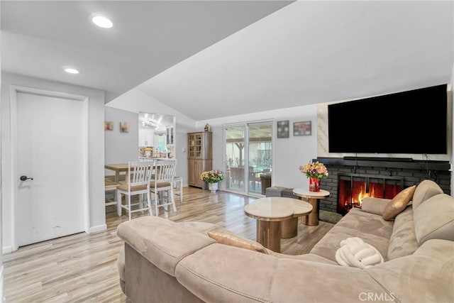 living room with light wood finished floors, recessed lighting, a fireplace, and lofted ceiling