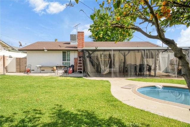 back of property featuring a patio area, a fenced backyard, a yard, and a sunroom