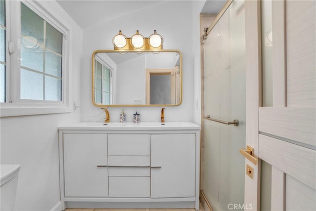 full bath with toilet, a sink, a shower, double vanity, and lofted ceiling