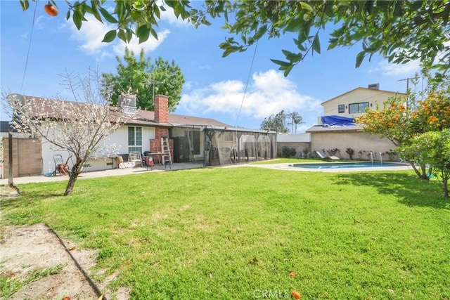 view of yard with a patio area, a fenced in pool, a sunroom, and fence