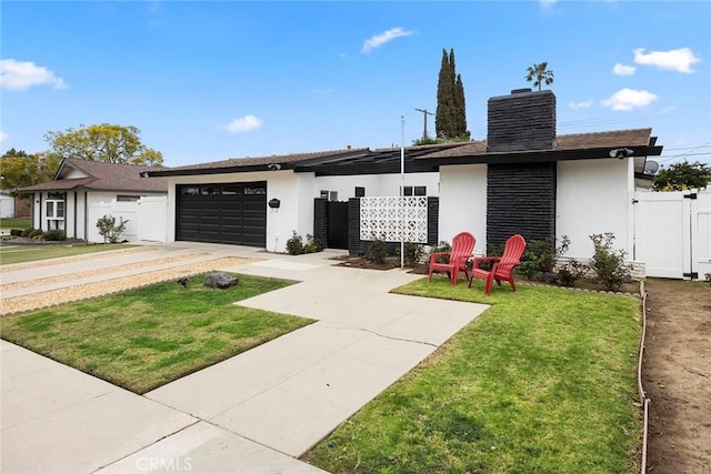 view of front of property featuring a gate, fence, an attached garage, and stucco siding