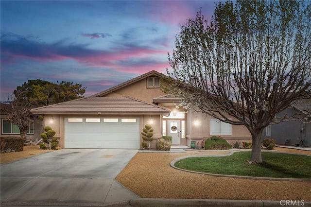 single story home with a garage, concrete driveway, stucco siding, and a tiled roof