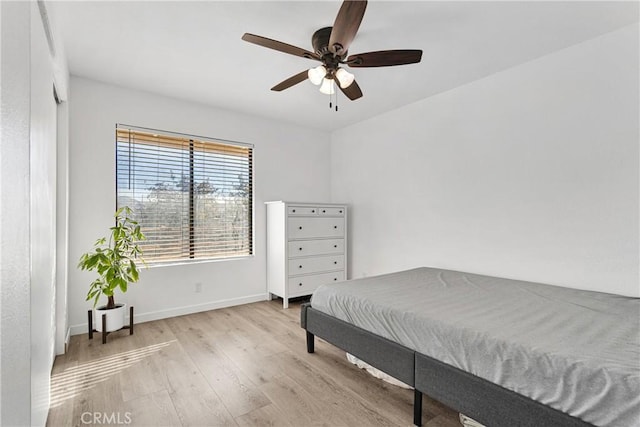 bedroom with wood finished floors, baseboards, and ceiling fan