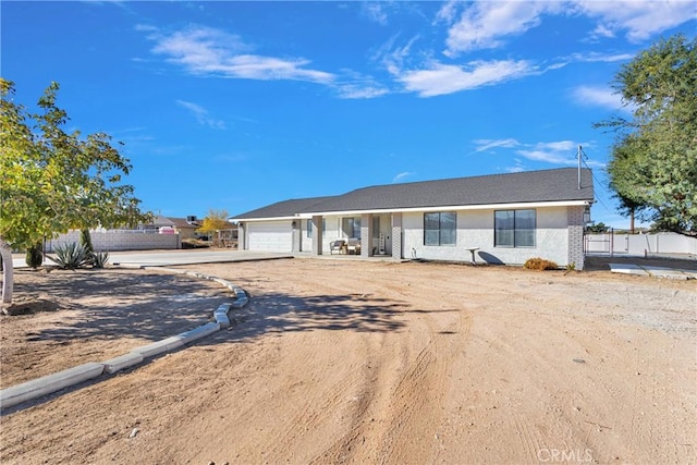 ranch-style home with a garage, driveway, and fence