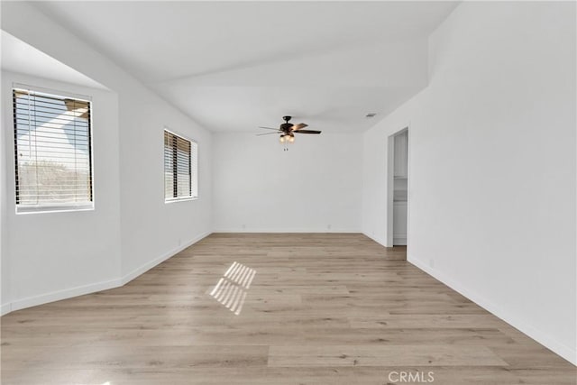 unfurnished room featuring baseboards, a ceiling fan, and light wood-style floors