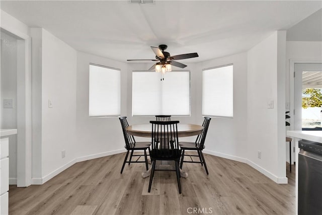 dining room featuring ceiling fan, light wood-type flooring, and baseboards