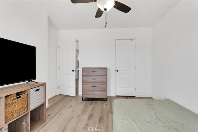 unfurnished bedroom featuring light wood-style flooring, baseboards, and ceiling fan