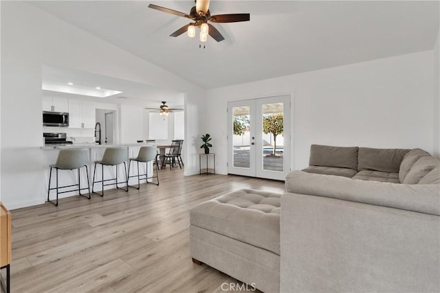 living area featuring recessed lighting, ceiling fan, vaulted ceiling, french doors, and light wood-type flooring