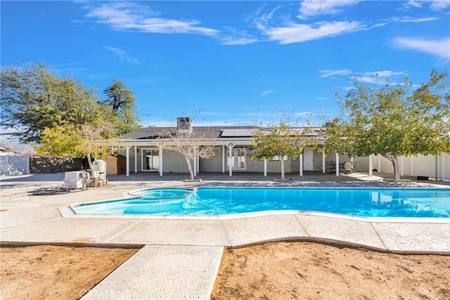 view of swimming pool with a patio area, a pool with connected hot tub, and fence private yard