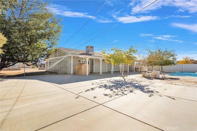 view of front of home with a fenced in pool, a patio, and fence