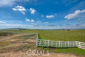 view of yard featuring a rural view and fence