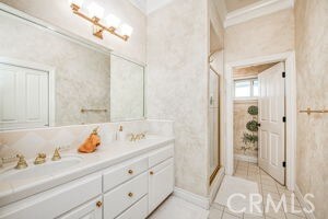 full bathroom featuring a stall shower, vanity, and tile patterned flooring
