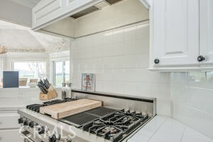 kitchen with range, white cabinets, and light countertops
