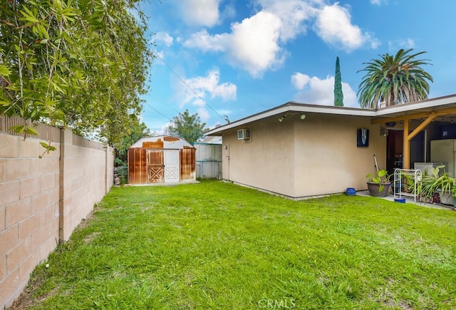 view of yard with an outdoor structure, a storage shed, and a fenced backyard