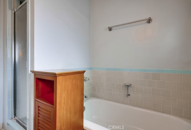 bathroom featuring a shower stall and a garden tub