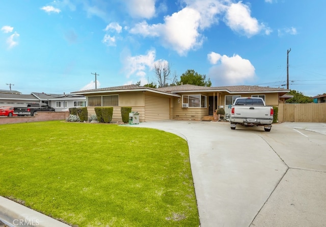 ranch-style home with concrete driveway, fence, and a front lawn