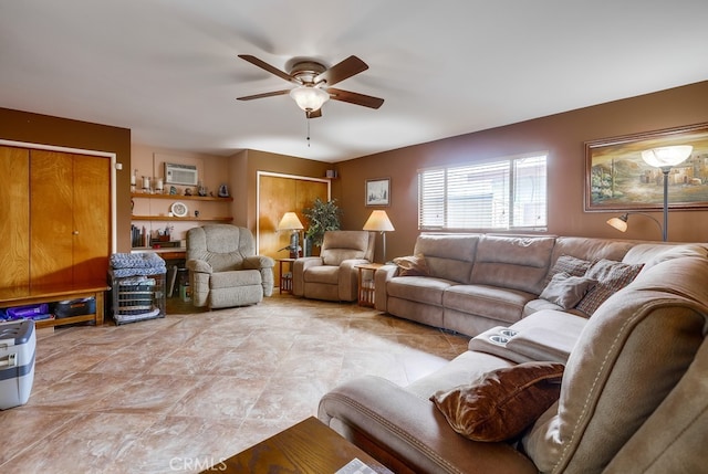 living room with a wall unit AC and a ceiling fan