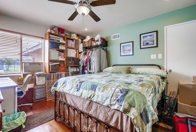 bedroom featuring visible vents, cooling unit, ceiling fan, and wood finished floors