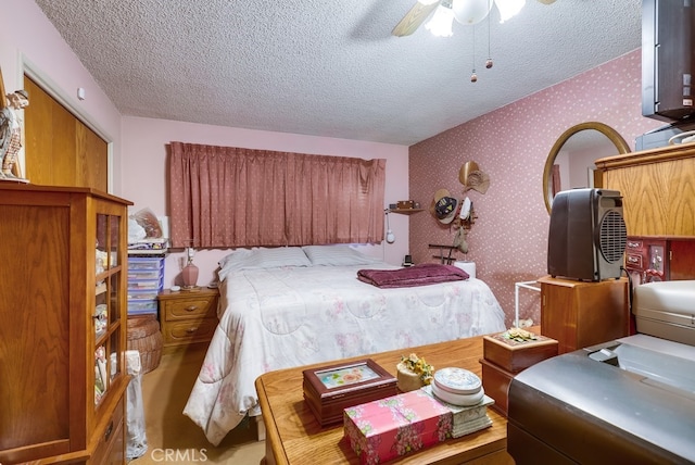 bedroom with wallpapered walls, ceiling fan, and a textured ceiling