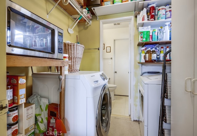 washroom featuring laundry area, separate washer and dryer, and visible vents