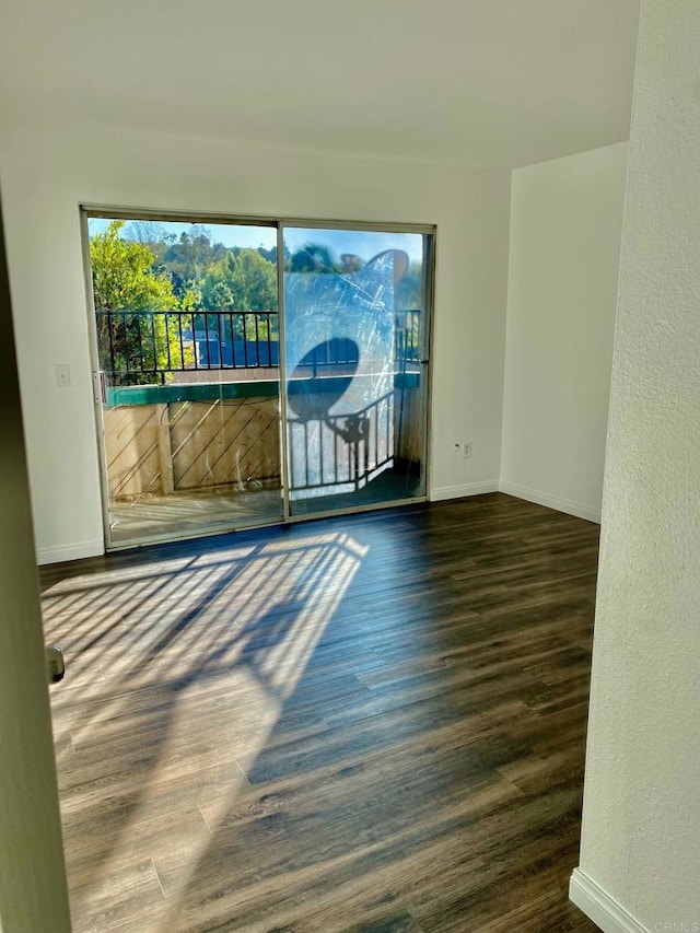 empty room with baseboards and wood finished floors