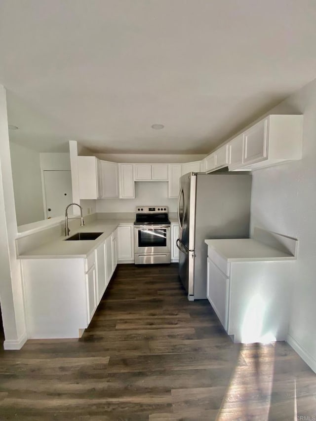 kitchen with dark wood-style flooring, a sink, light countertops, appliances with stainless steel finishes, and white cabinetry