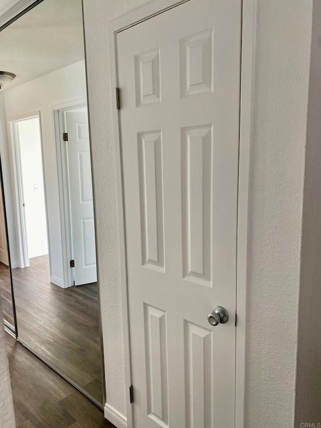 interior space with wood finished floors and a textured wall