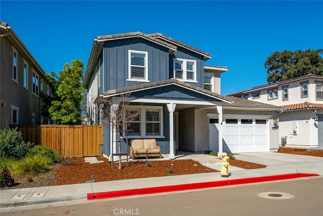 traditional-style home with driveway, a tile roof, fence, board and batten siding, and an attached garage