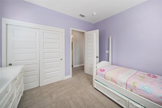 bedroom featuring visible vents, baseboards, light colored carpet, and a closet