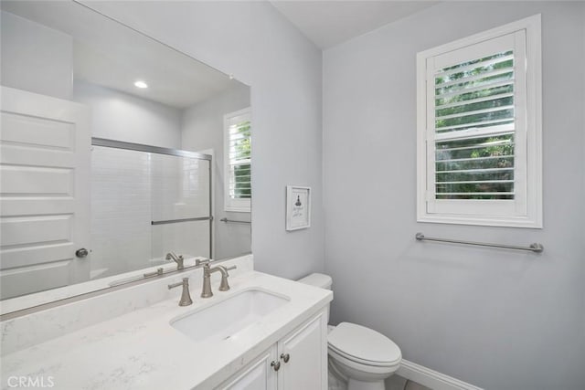 bathroom featuring baseboards, toilet, vanity, and a shower stall