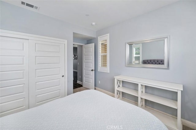 bedroom featuring visible vents, baseboards, and a closet