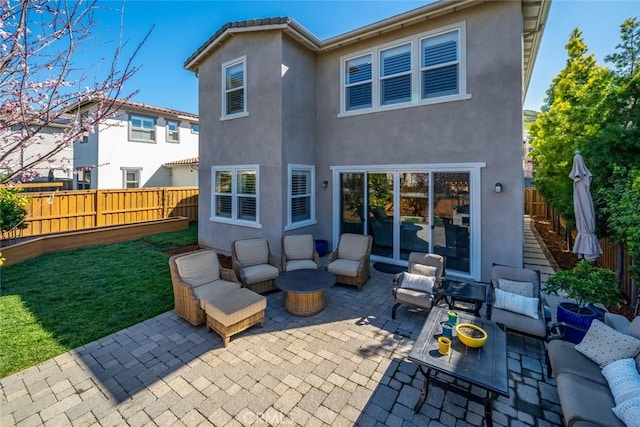 back of property with stucco siding, an outdoor hangout area, a patio, and fence