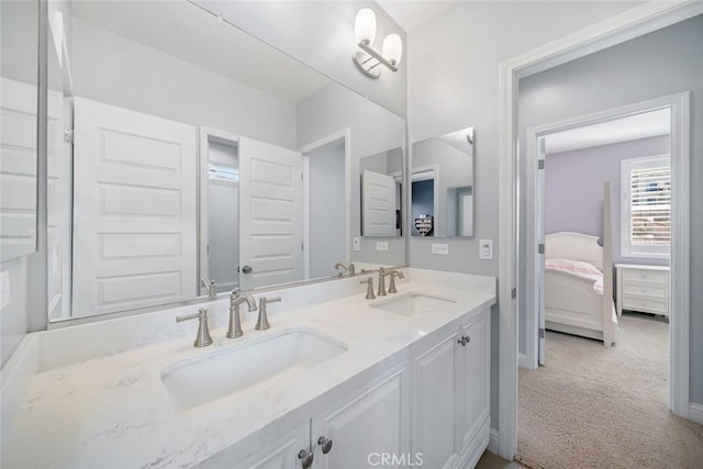 full bathroom with a sink, connected bathroom, baseboards, and double vanity