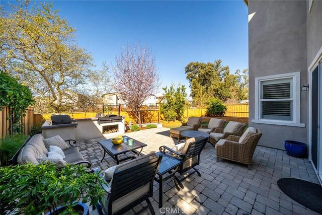 view of patio with an outdoor hangout area, exterior kitchen, and a fenced backyard