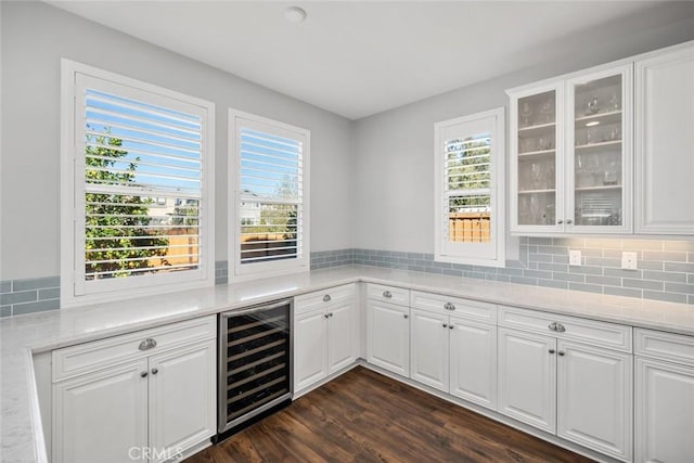 kitchen featuring glass insert cabinets, wine cooler, light countertops, white cabinetry, and dark wood-style flooring