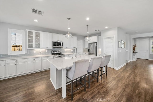 kitchen with visible vents, dark wood-style flooring, a sink, appliances with stainless steel finishes, and white cabinetry