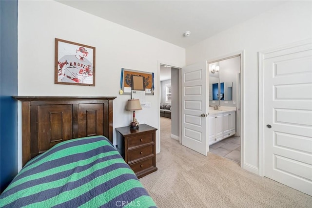 bedroom featuring a sink, light carpet, and ensuite bathroom