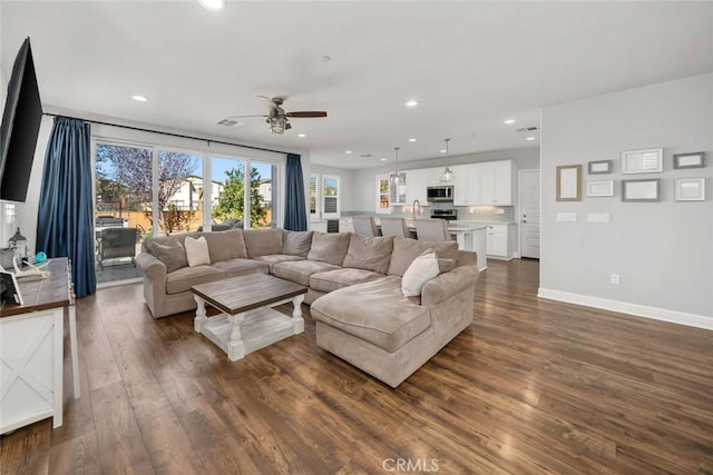 living area with a ceiling fan, visible vents, baseboards, dark wood finished floors, and recessed lighting