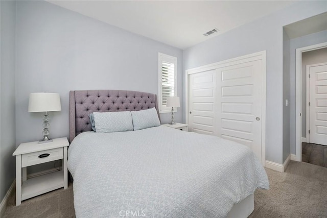 carpeted bedroom with a closet, visible vents, and baseboards