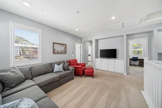 living area featuring recessed lighting, visible vents, and light colored carpet