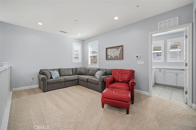 living room with recessed lighting, visible vents, and light colored carpet