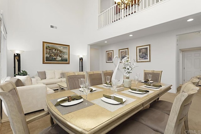 carpeted dining area with visible vents, recessed lighting, and a high ceiling