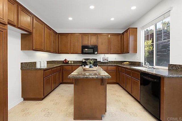 kitchen with dark stone countertops, recessed lighting, a sink, black appliances, and a center island