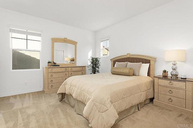 bedroom with light colored carpet and baseboards