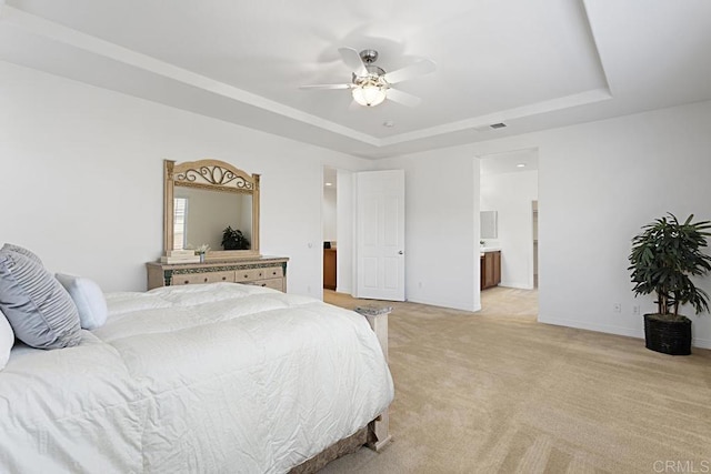 bedroom with visible vents, light colored carpet, a raised ceiling, and baseboards