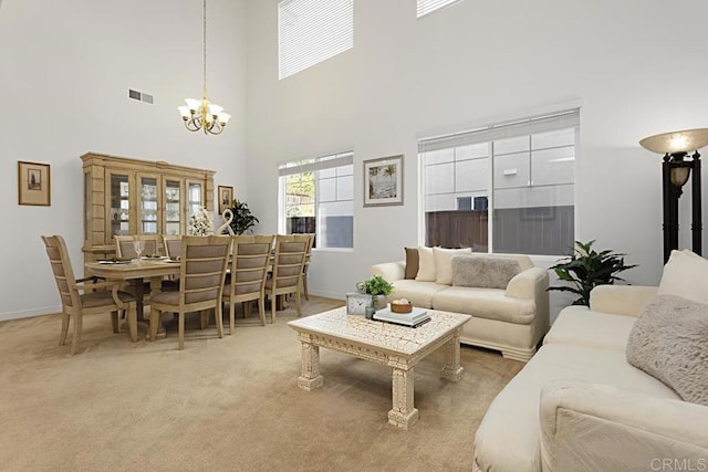 carpeted living area featuring an inviting chandelier, baseboards, and visible vents