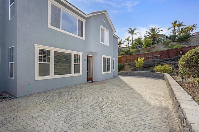 back of property featuring a patio area, stucco siding, and fence