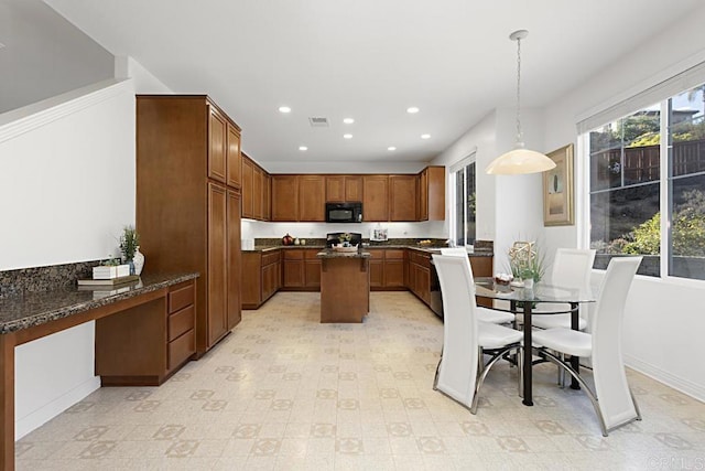 kitchen with visible vents, built in study area, recessed lighting, black microwave, and pendant lighting