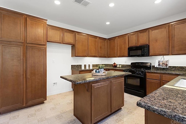 kitchen featuring visible vents, a kitchen island, light floors, recessed lighting, and black appliances